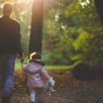 A Man and a Little Girl Walking in the Forest Area