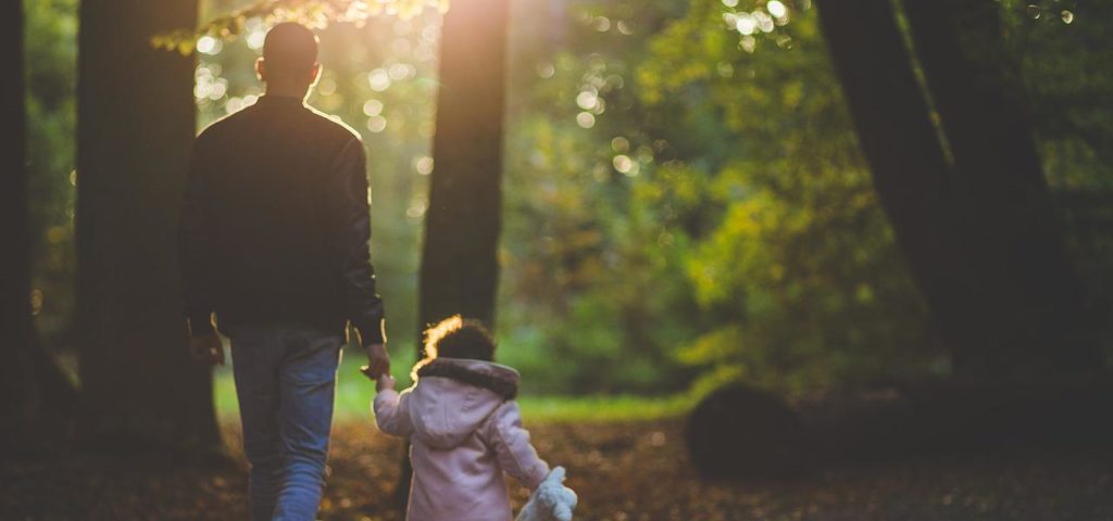 A Man and a Little Girl Walking in the Forest Area